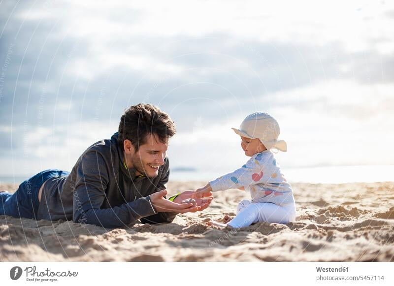 Spain, Lanzarote, father playing with baby girl on the beach daughter daughters fathers daddy dads papa beaches infants nurselings babies child children family