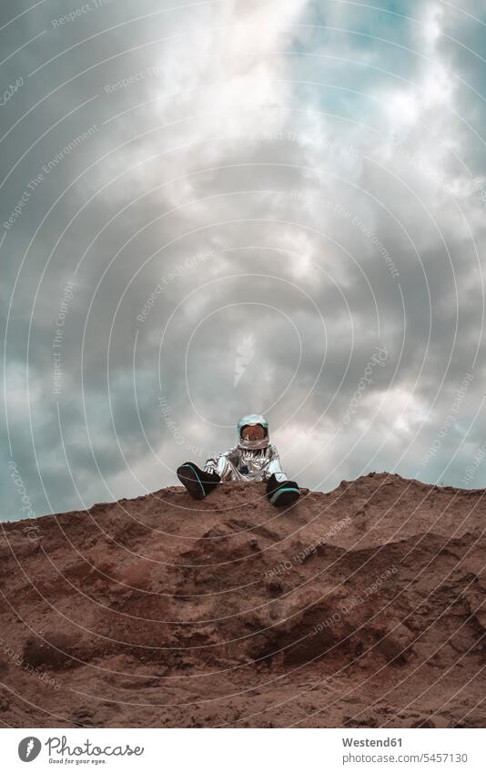 Spaceman stitting on slope of nameless planet astronaut astronauts sitting Seated planets unknown spaceman spacemen astronautics space travel traffic