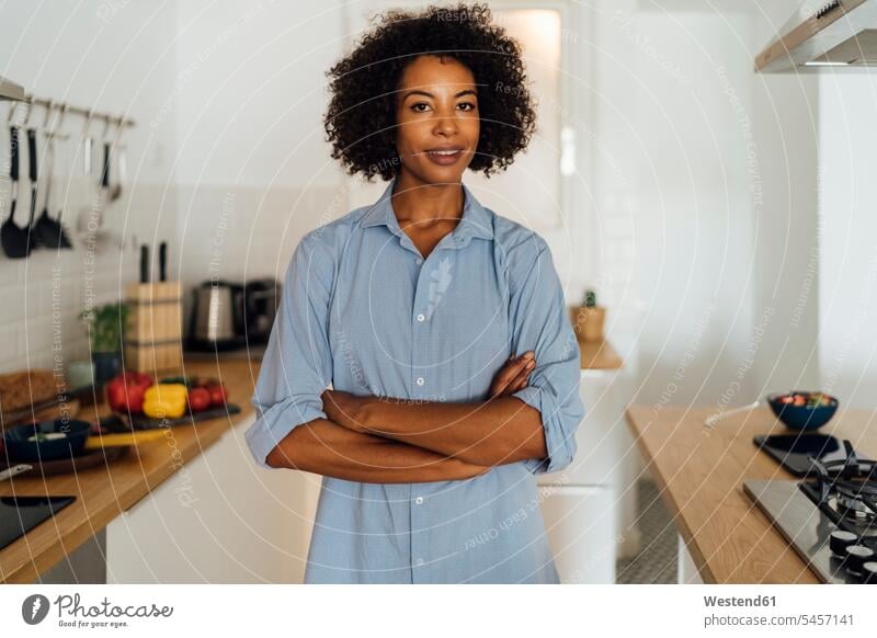 Confident woman standing in her kitchen with arms crossed mid adult women mid adult woman mid-adult women mid-adult woman Arms Folded Folded Arms Crossed Arms