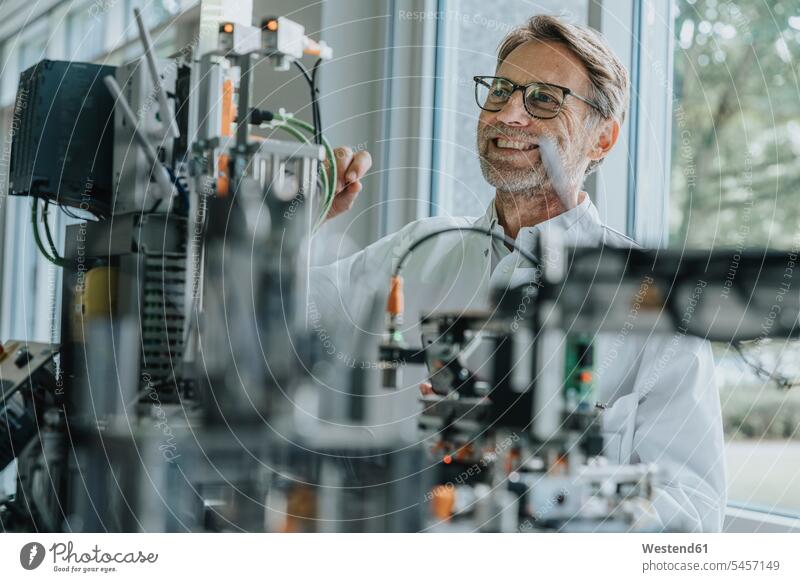 Smiling male technician examining machinery in laboratory color image colour image indoors indoor shot indoor shots interior interior view Interiors scientist