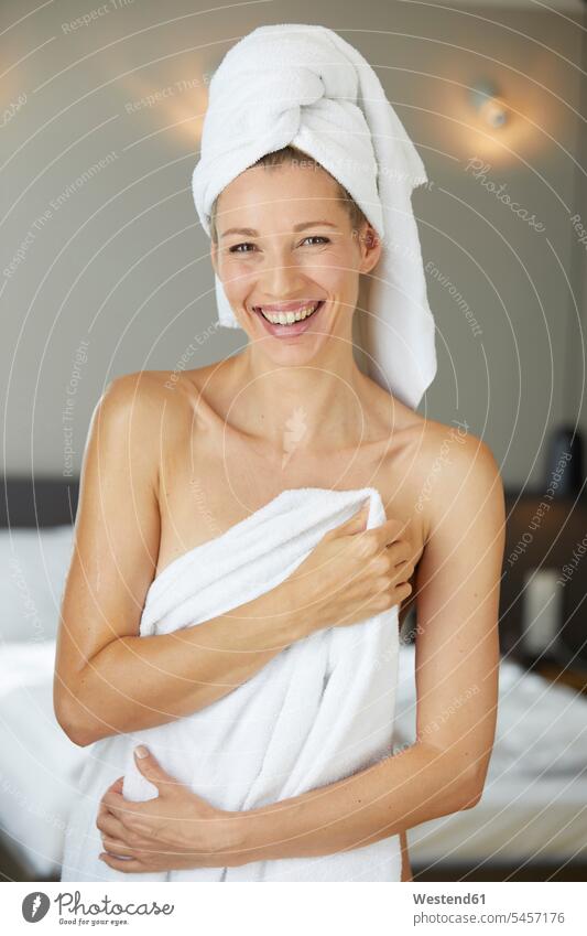 Portrait of laughing woman wrapped in towel standing in bedroom in the morning portrait portraits Domestic Bedroom Wrapped Up females women Laughter smiling