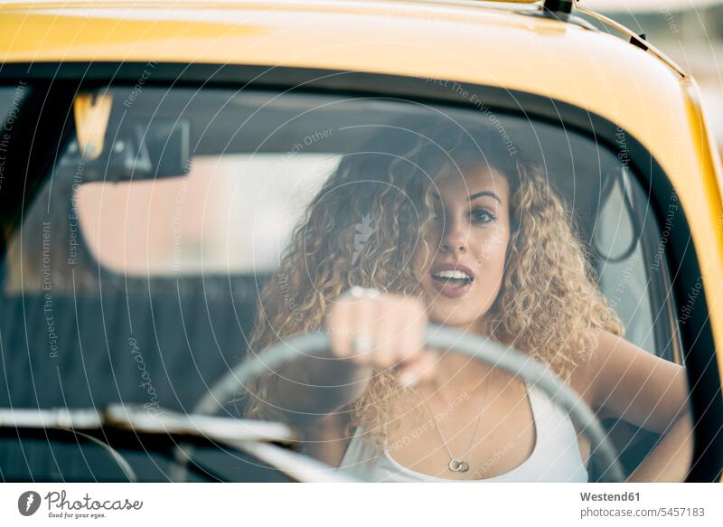 Portrait of surprised blond woman driving classic car females women amazed drive blond hair blonde hair car driving motoring portrait portraits Adults grown-ups