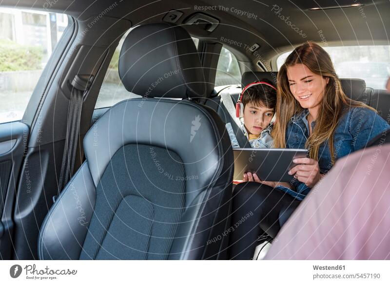 Family on a road trip with mother and son sharing tablet driving drive car automobile Auto cars motorcars Automobiles digitizer Tablet Computer Tablet PC