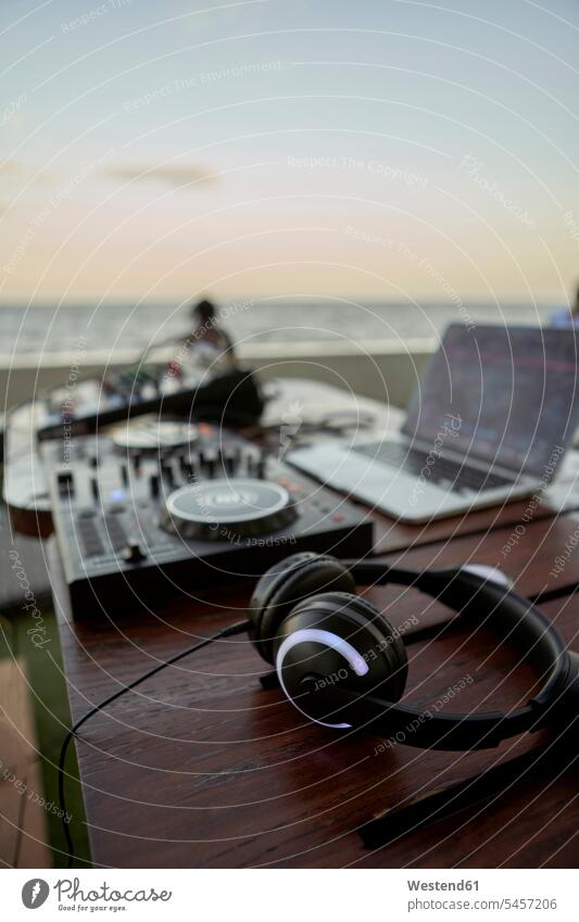 Headphones lying on table in front of mixing board background people background person People In Background People In The Background blurred background