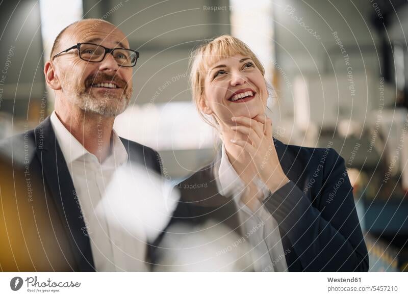 Portrait of happy businessman and businesswoman in a factory looking up human human being human beings humans person persons caucasian appearance