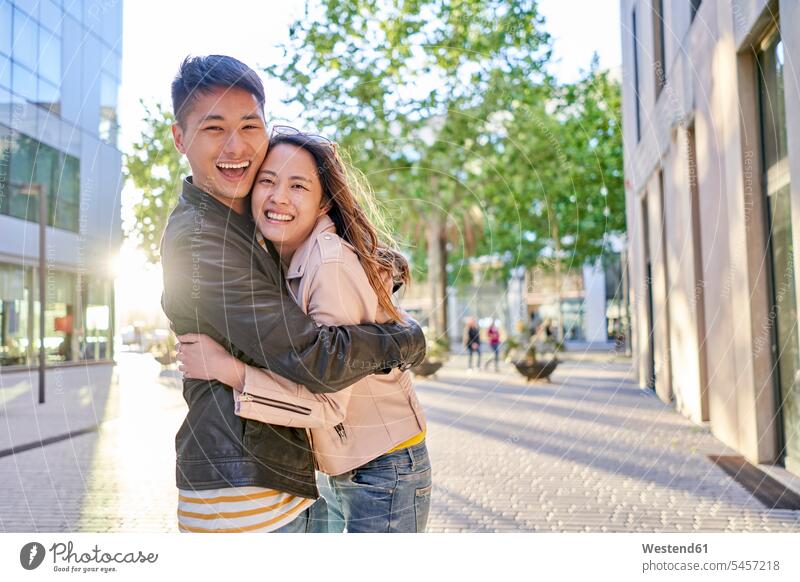 Portrait of happy couple in the city embrace Embracement hug hugging in the evening delight enjoyment Pleasant pleasure Emotions Feeling Feelings Sentiment