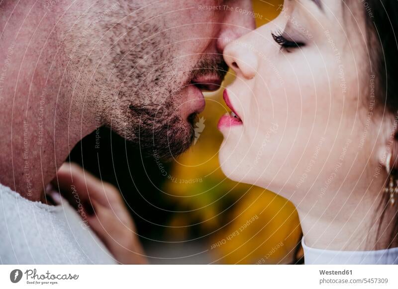 Beautiful woman kissing male partner while standing outdoors color image colour image location shots outdoor shot outdoor shots day daylight shot daylight shots