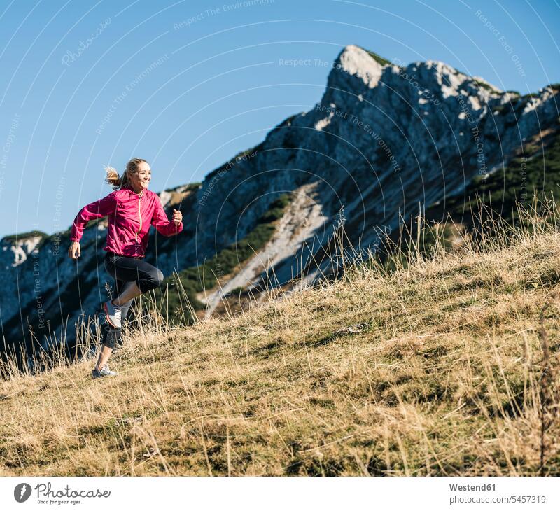 Austria, Tyrol, woman running in the mountains mountain range mountain ranges females women landscape landscapes scenery terrain Adults grown-ups grownups adult