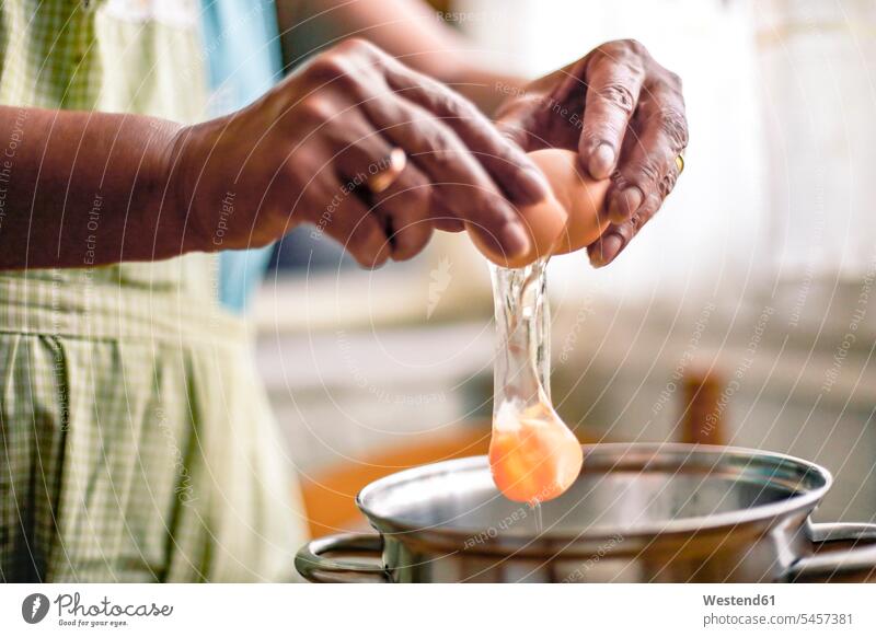 Hands of a woman breaking an egg Cooking Pot Pots Cooking Pots females women Tradition traditional Traditions preparation prepare preparing baking bake cracking