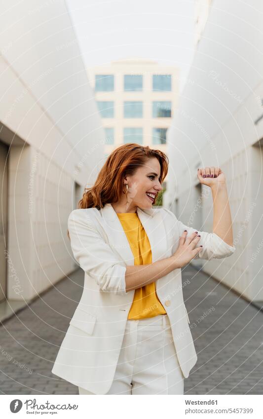 Energetic businesswoman in white pant suit, flexing her muscles Occupation Work job jobs profession professional occupation business life business world