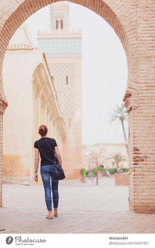 Morocco, Marrakesh, back view of woman looking at Kasbah Mosque travelling traveling Mosques minaret Minarets shoulder bag Traveller Travellers Travelers