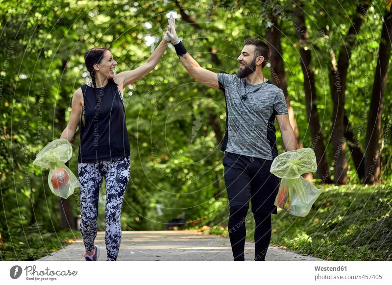 Happy couple plogging on forest path human human being human beings humans person persons caucasian appearance caucasian ethnicity european 2 2 people 2 persons