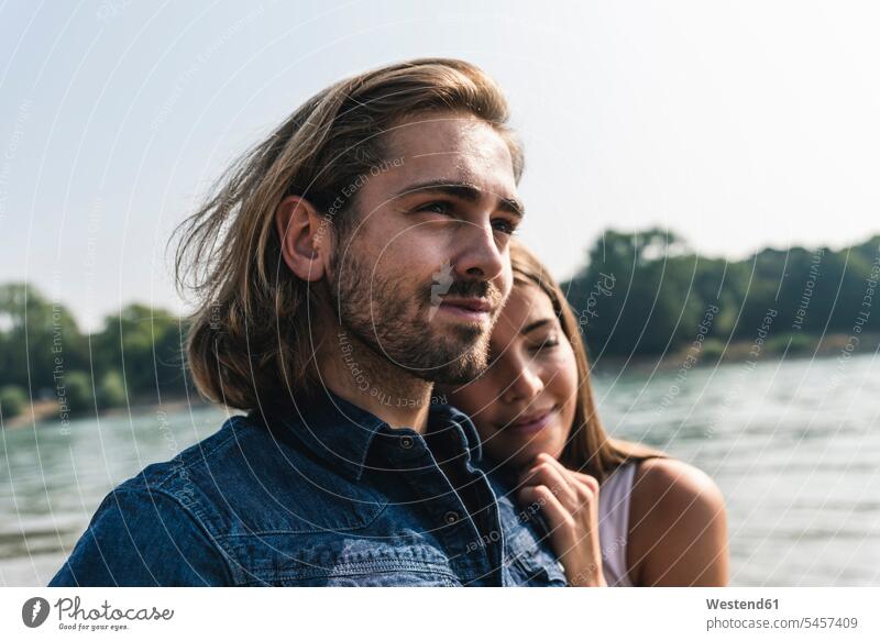 Portrait of young couple in love at the riverside River Rivers twosomes partnership couples riverbank portrait portraits water waters body of water people