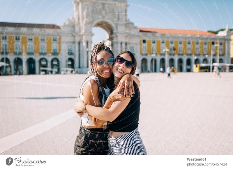 Happy women embracing each other at Praca Do Comercio, Lisbon, Portugal color image colour image outdoors location shots outdoor shot outdoor shots day