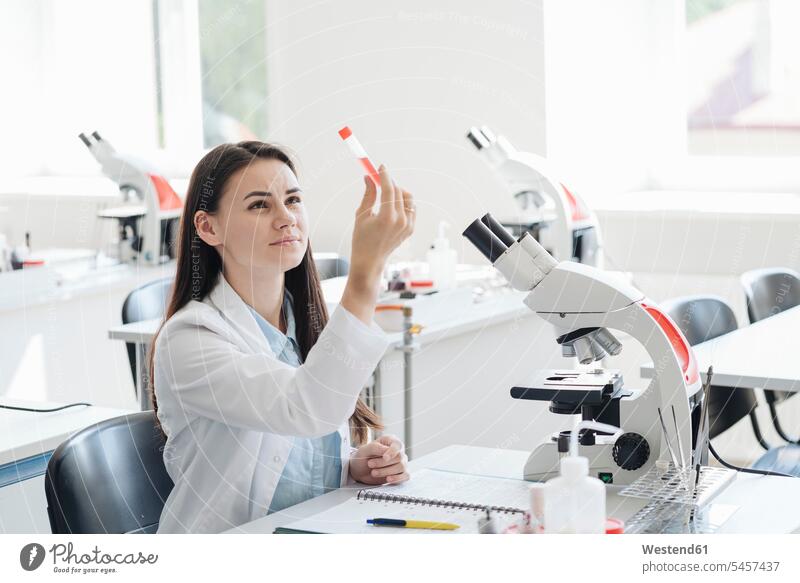 Young female researcher in white coat examining laboratory sample human human being human beings humans person persons caucasian appearance caucasian ethnicity