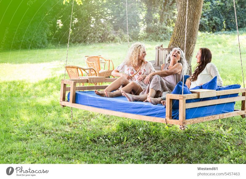 Women of a family relaxing in garden, sitting on a swing bed Germany only women women only Swing bed beautiful Woman beautiful Women quality of life