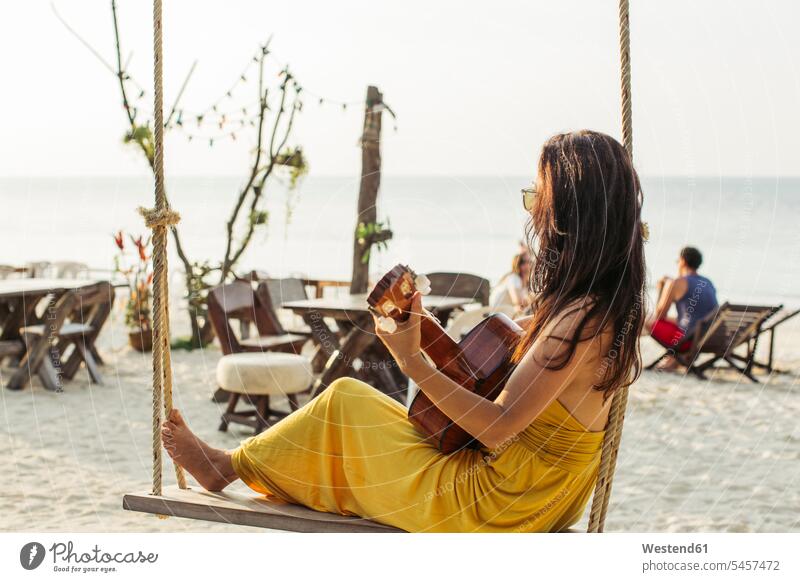 Thailand, Koh Phangan, woman playing guitar at the beach guitars females women beaches stringed instrument stringed instruments musical instrument