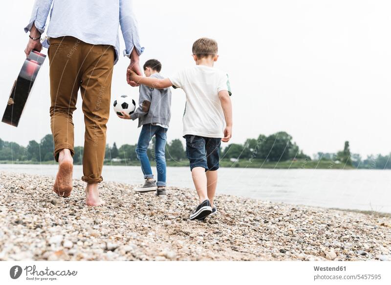 Father with two sons walking at the riverside manchild manchildren going River Rivers father pa fathers daddy dads papa family families people persons