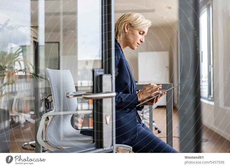 Blond businesswoman using tablet in conference room Occupation Work job jobs profession professional occupation business life business world business person