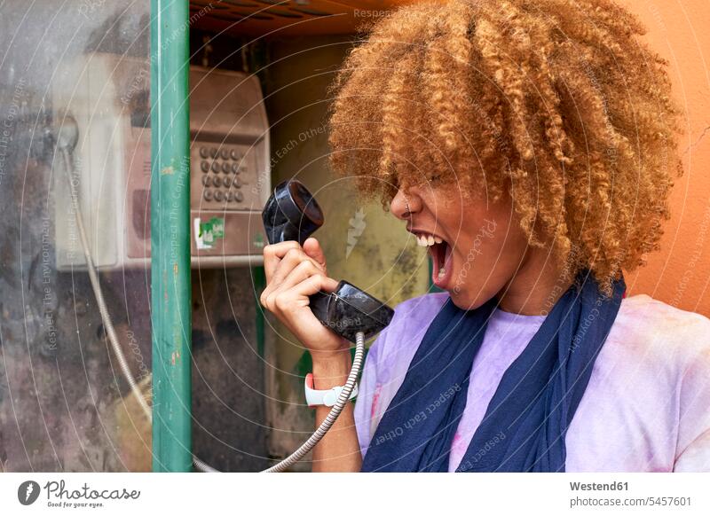 Woman yelling into old-fashioned telephone receiver human human being human beings humans person persons African black black ethnicity coloured adult grown-up