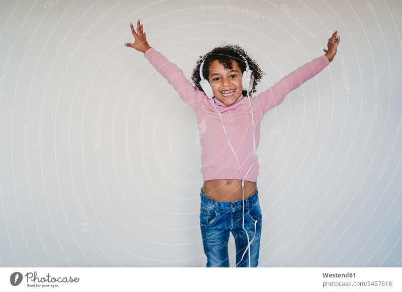 Portrait of happy little girl wearing pink turtleneck pullover listening music with headphones human human being human beings humans person persons 1
