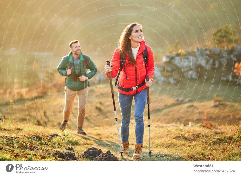 Couple walking on alpine meadow on a hiking trip in the mountains excursion Getaway Trip Tours Trips hiking tour walking tour mountain range mountain ranges