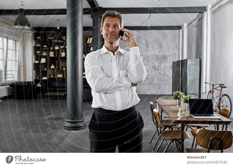 Portrait of mature business man using smartphone in loft office Smartphone iPhone Smartphones on the phone call telephoning On The Telephone calling portrait