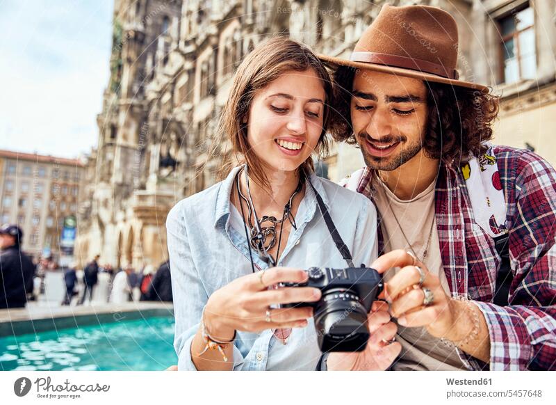 Young couple taking a photo friends mate images picture pictures photographs photos hats cameras hold smile delight enjoyment Pleasant pleasure happy pleased