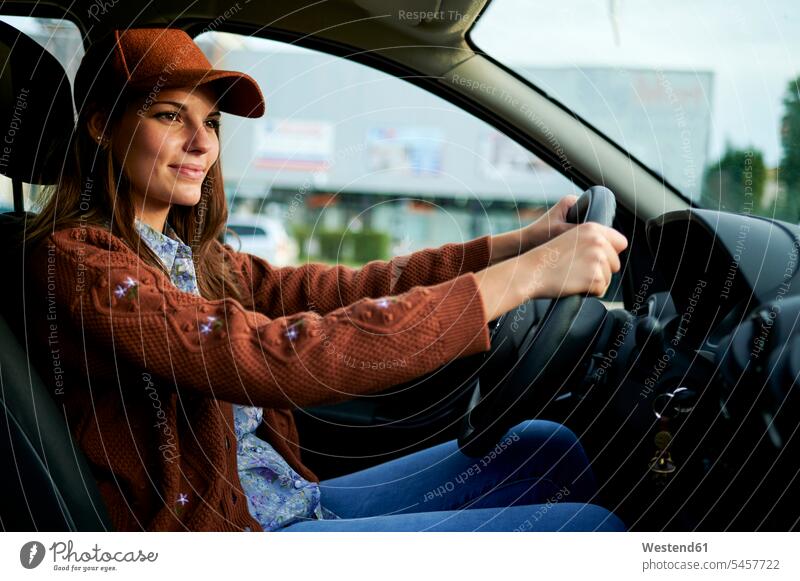 Young woman smiling while driving car in city color image colour image day daylight shot daylight shots day shots daytime casual clothing casual wear