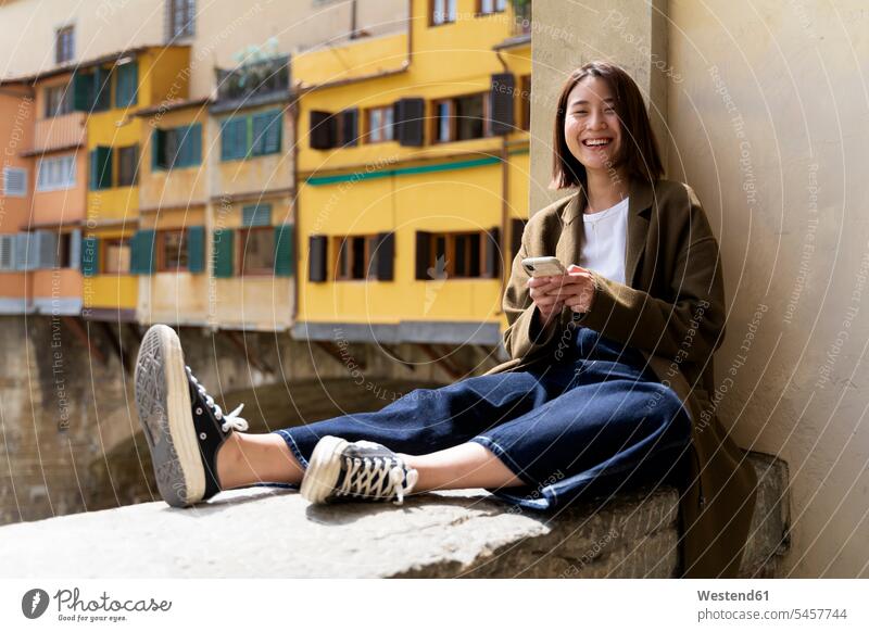 Italy, Florence, happy young woman resting on a wall in the city residential house Residential Buildings residential home cheerful gaiety Joyous glad