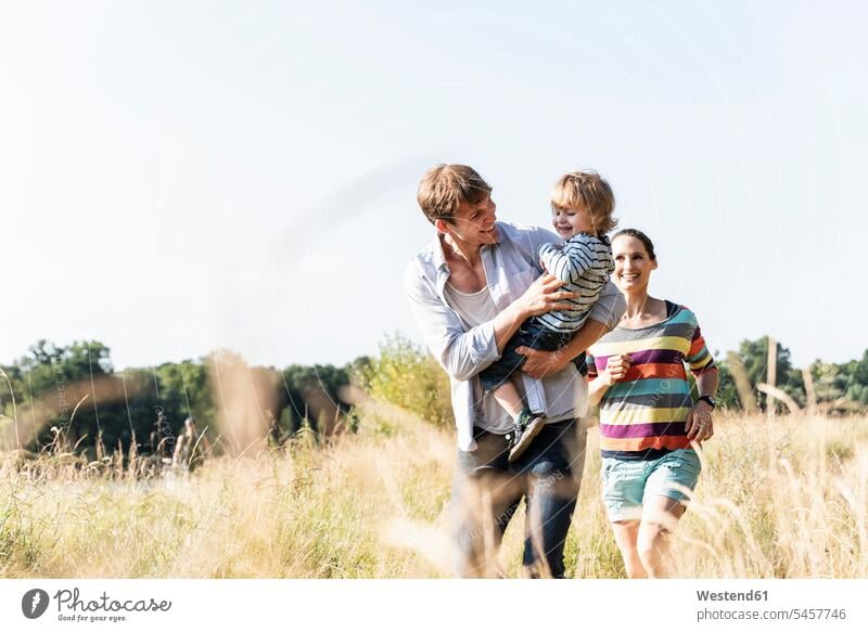 Happy family walking at the riverside on a beautiful summer day going happiness happy Meadow Meadows summer time summery summertime Plant Plants caucasian