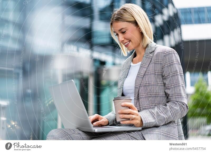 Smiling young businesswoman using laptop in the city Occupation Work job jobs profession professional occupation business life business world business person