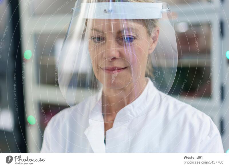 Close-up of mature female scientist wearing protective face shield at laboratory color image colour image indoors indoor shot indoor shots interior