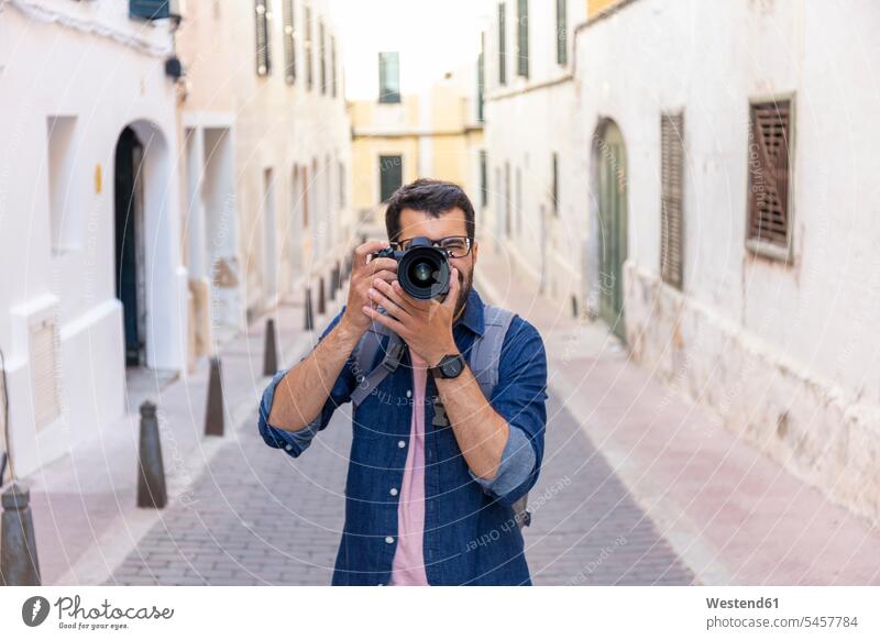 Man taking photos with camera in the city, Mao, Menorca, Spain touristic tourists back-pack back-packs backpacks rucksack rucksacks Eye Glasses Eyeglasses specs