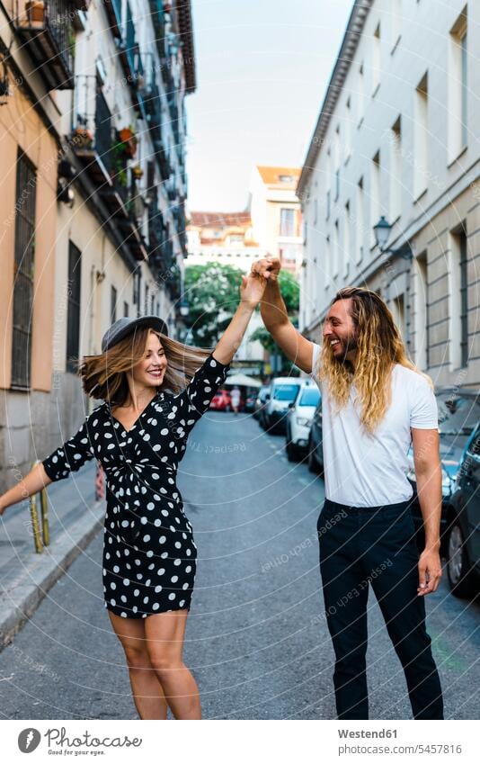 Stylish couple dancing on street amidst buildings in city color image colour image Spain leisure activity leisure activities free time leisure time
