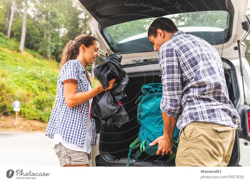 Italy, Massa, couple taking the bags from the car ready to hike in the Alpi Apuane mountains automobile Auto cars motorcars Automobiles twosomes partnership