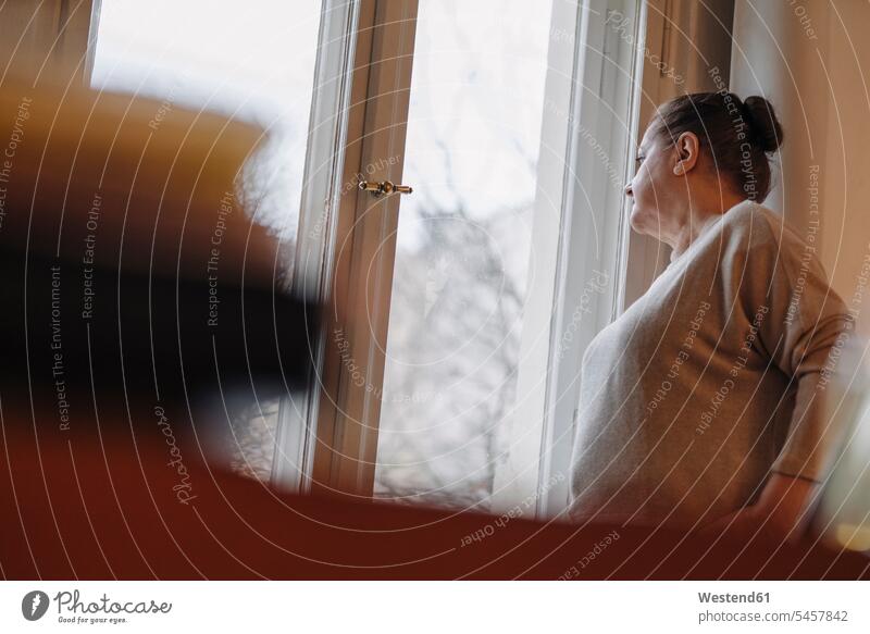 Serious senior woman looking out of window at home human human being human beings humans person persons caucasian appearance caucasian ethnicity european 1