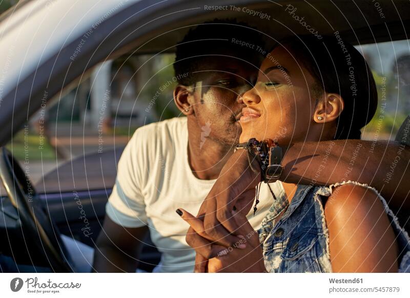 Young couple sitting car, kissing transport motor vehicles road vehicle road vehicles Auto automobile Automobiles cars motorcar motorcars kisses Seated happy