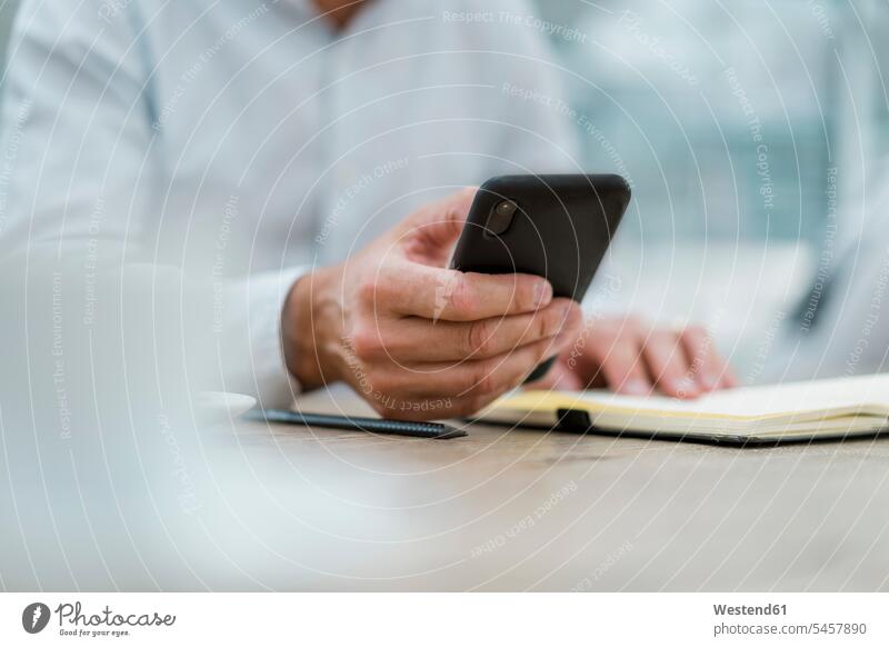 Close-up of businessman with notebook and cell phone human human being human beings humans person persons caucasian appearance caucasian ethnicity european 1
