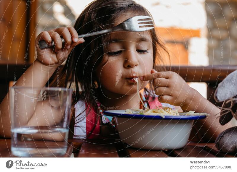 Girl eating food while sitting by table at home color image colour image indoors indoor shot indoor shots interior interior view Interiors 2-3 years
