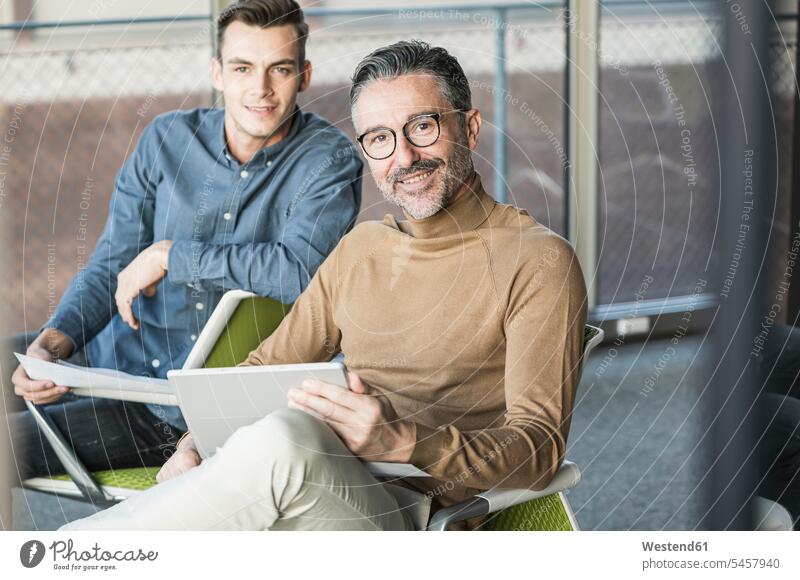 Portrait of smiling mature businessman with tablet and young man in office colleague associate associates partner partners partnerships Occupation Work job jobs