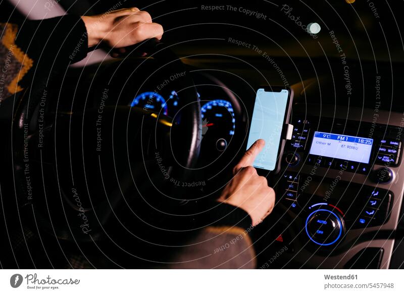 Man using cell phone with road maps in the car at night by night nite night photography man men males mobile phone mobiles mobile phones Cellphone cell phones