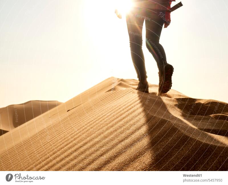 Low section of woman waking on the ridge of a dune in the desert, Walvis Bay, Namibia (value=0) go going walk experience Experiences explore exploring free