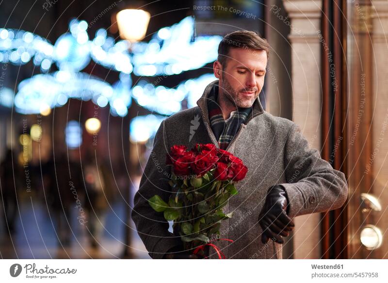 Portrait of waiting man with bunch of red roses checking the time Bunch of Flowers Bouquet Flower Bouquet Bouquet of Flowers Flower Bouquets Bunches of Flowers
