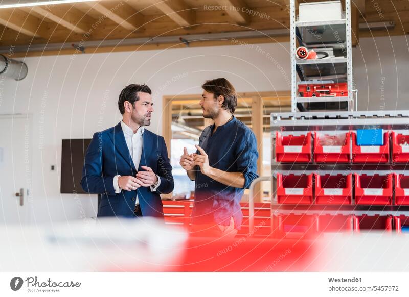 Businessman and employee talking in factory human human being human beings humans person persons caucasian appearance caucasian ethnicity european 2 2 people