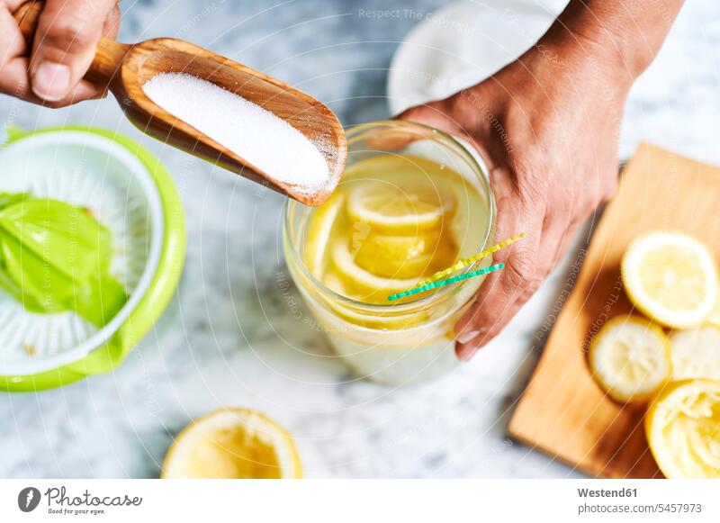 Hands of woman adding sugar to pitcher of homemade lemonade indoors indoor shot indoor shots interior interior view Interiors elevated view High Angle View