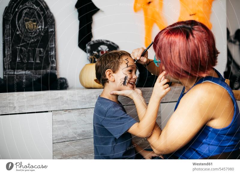 Mother painting her son's face for Halloween faces mother mommy mothers ma mummy mama sons manchild manchildren All Hallows' Eve head heads people persons