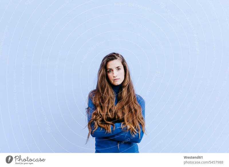 Portrait of young woman wearing blue turtleneck pullover in front of light blue wall human human being human beings humans person persons caucasian appearance