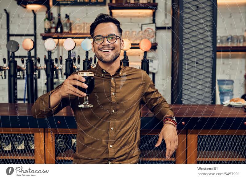 Portrait of a smiling man raising his beer glass in a pub human human being human beings humans person persons caucasian appearance caucasian ethnicity european