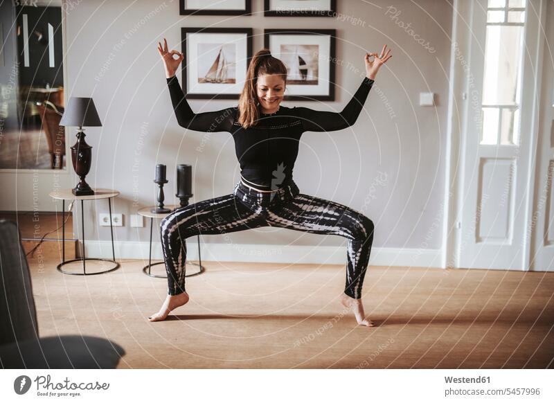 Woman practising yoga at home smile delight enjoyment Pleasant pleasure happy content Contented Emotion pleased free time leisure time balanced Equilibrium